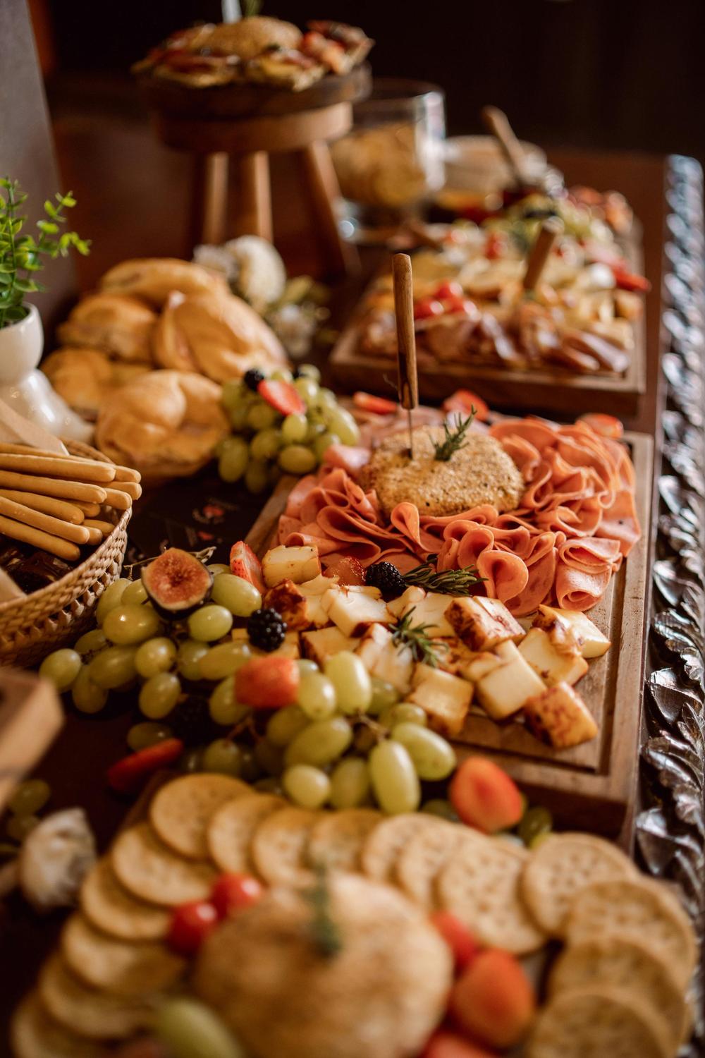 Grazing table styled with cheeses, grapes, breads and charcuterie for an event