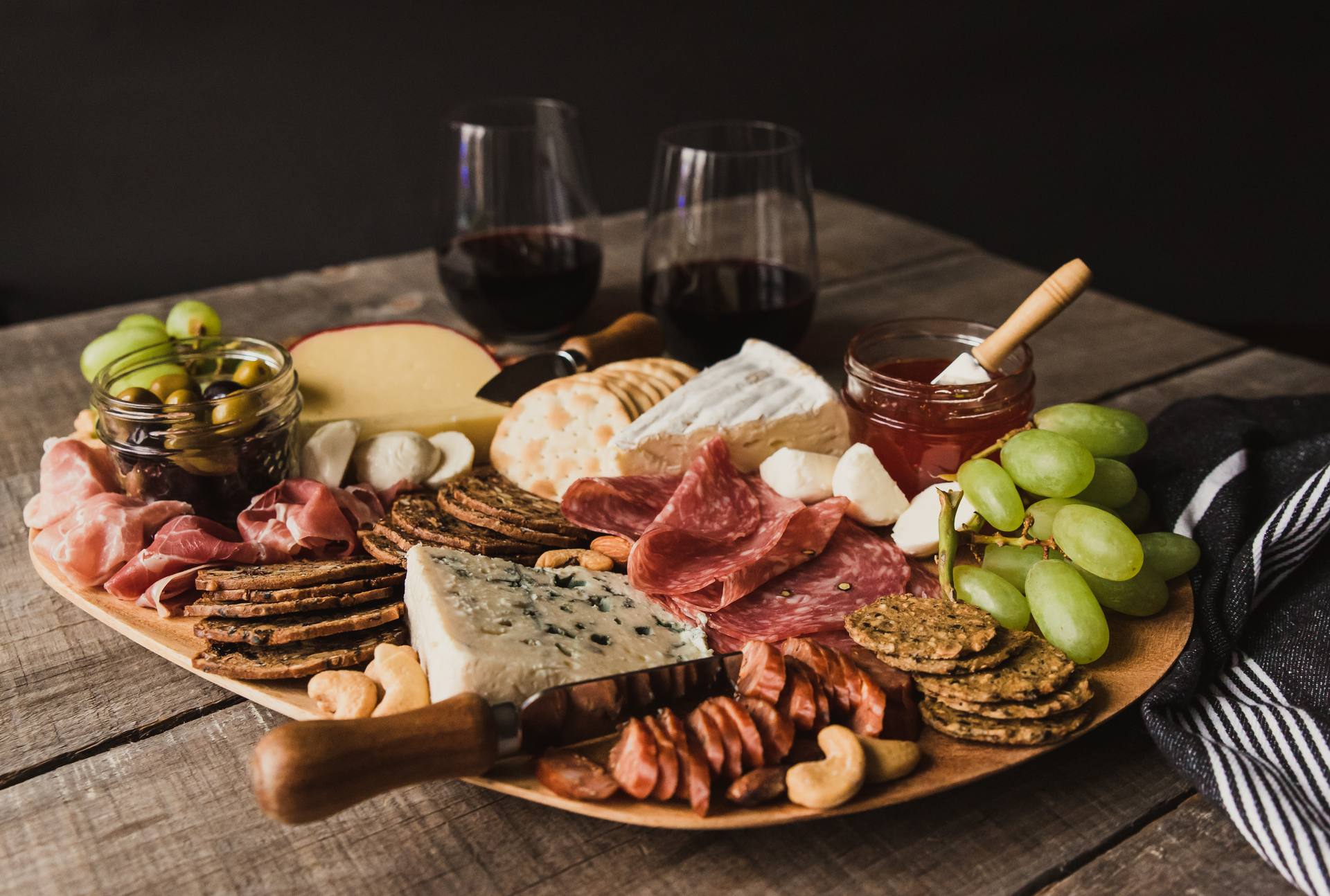 Luxury cheese and charcuterie board with artisan cheeses, cured meats, grapes and honey