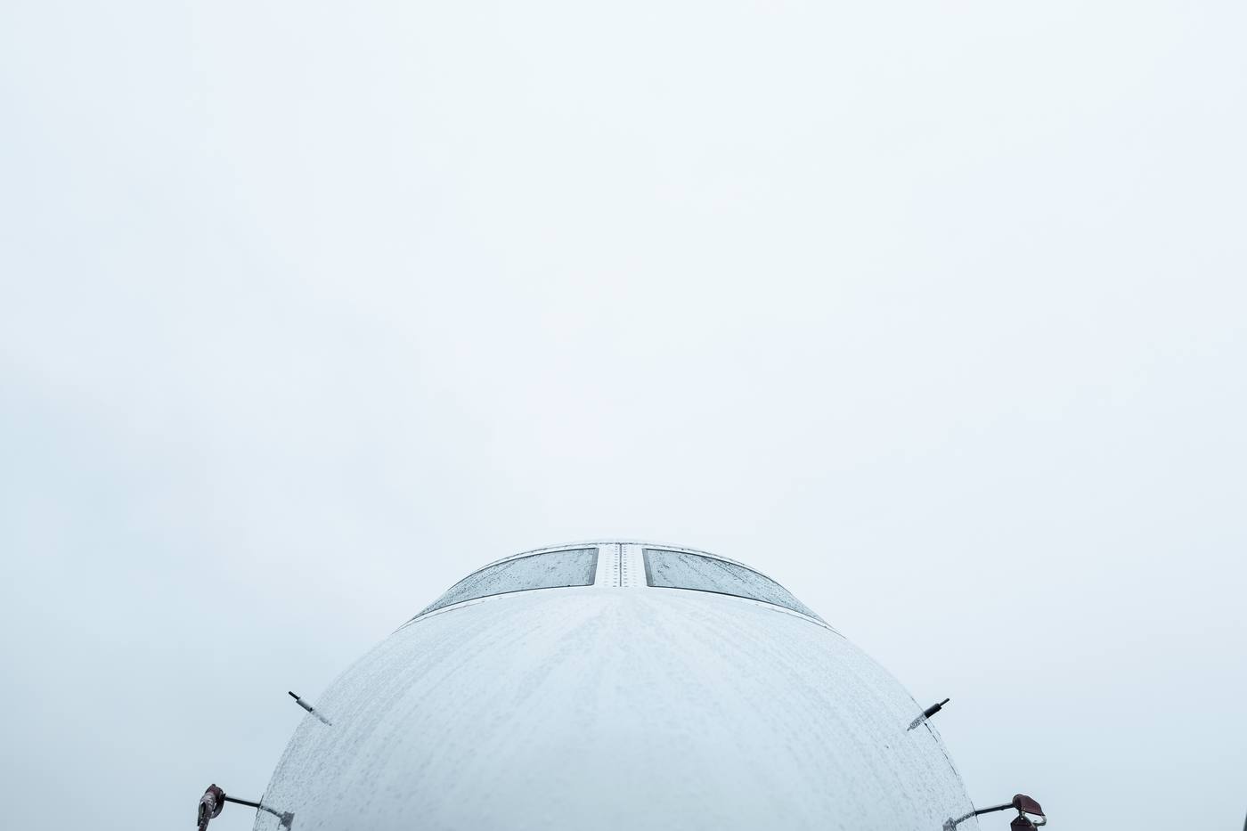 Private jet nose viewed from below against the sky